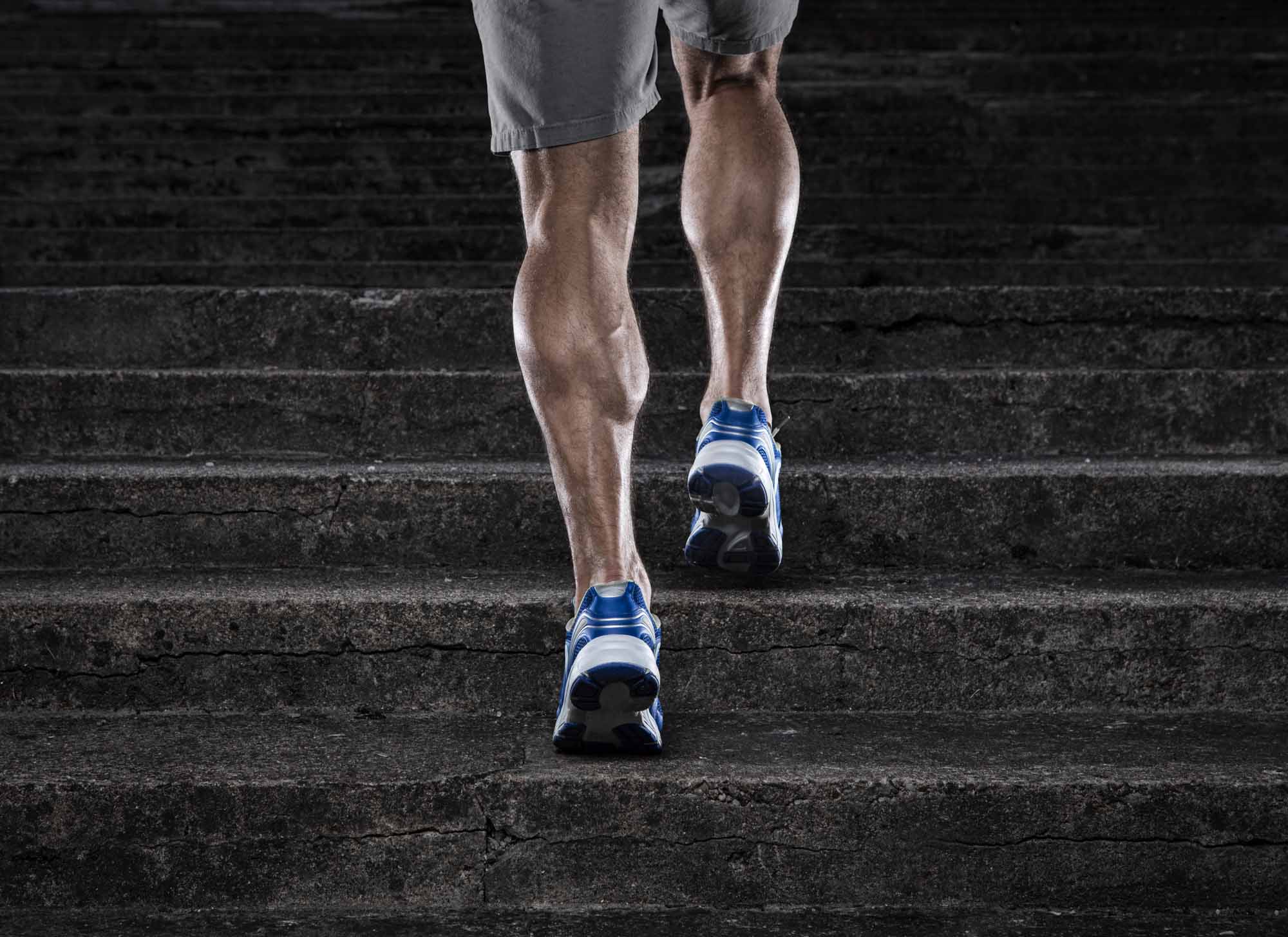 muscle legs running up stairs to showcase the article asking "can you build muscle from cardio"