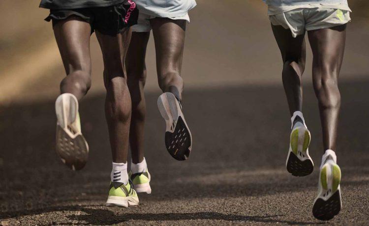 Runners wearing adizero boston 12 and adizero adios8 trainers made by adidas